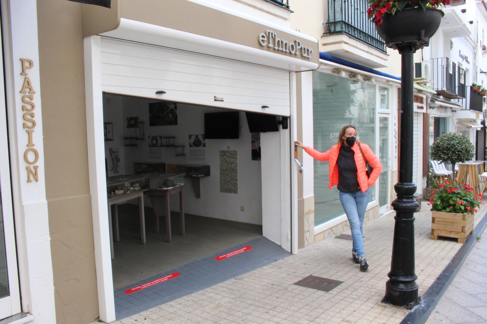 Una comerciante baja la persiana de su negocio en la última jornada de venta.