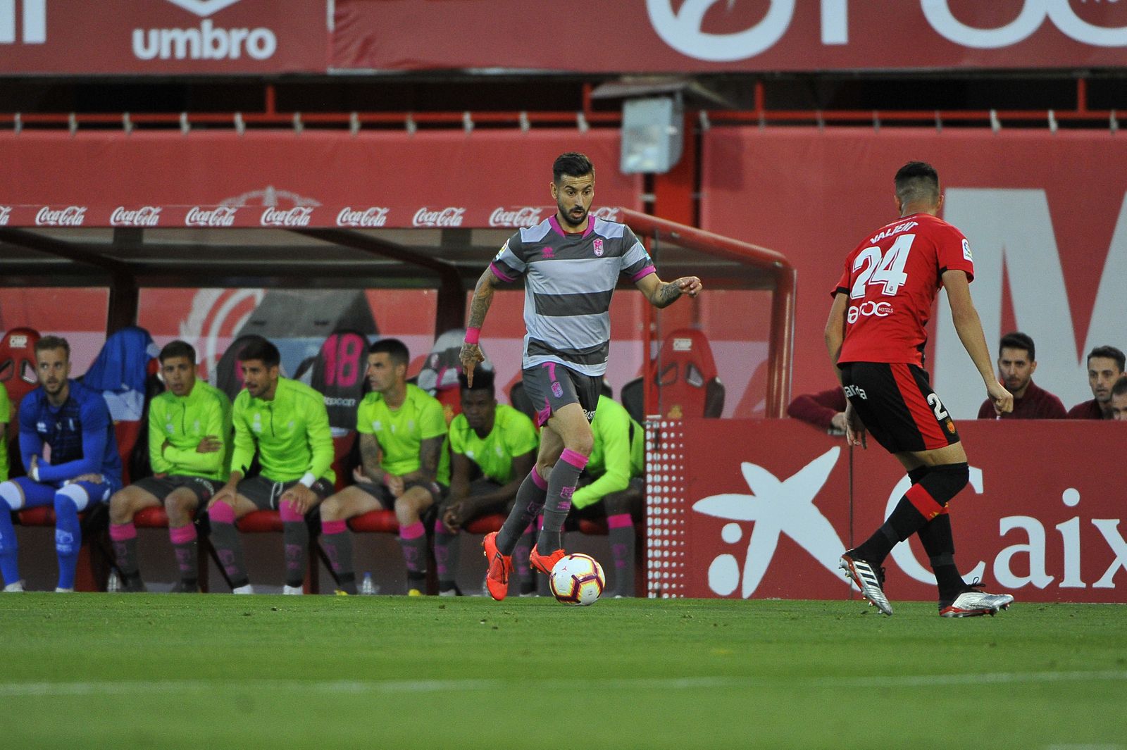 Vadillo encara a un jugador del Mallorca, con todo el banquillo del Granada de fondo