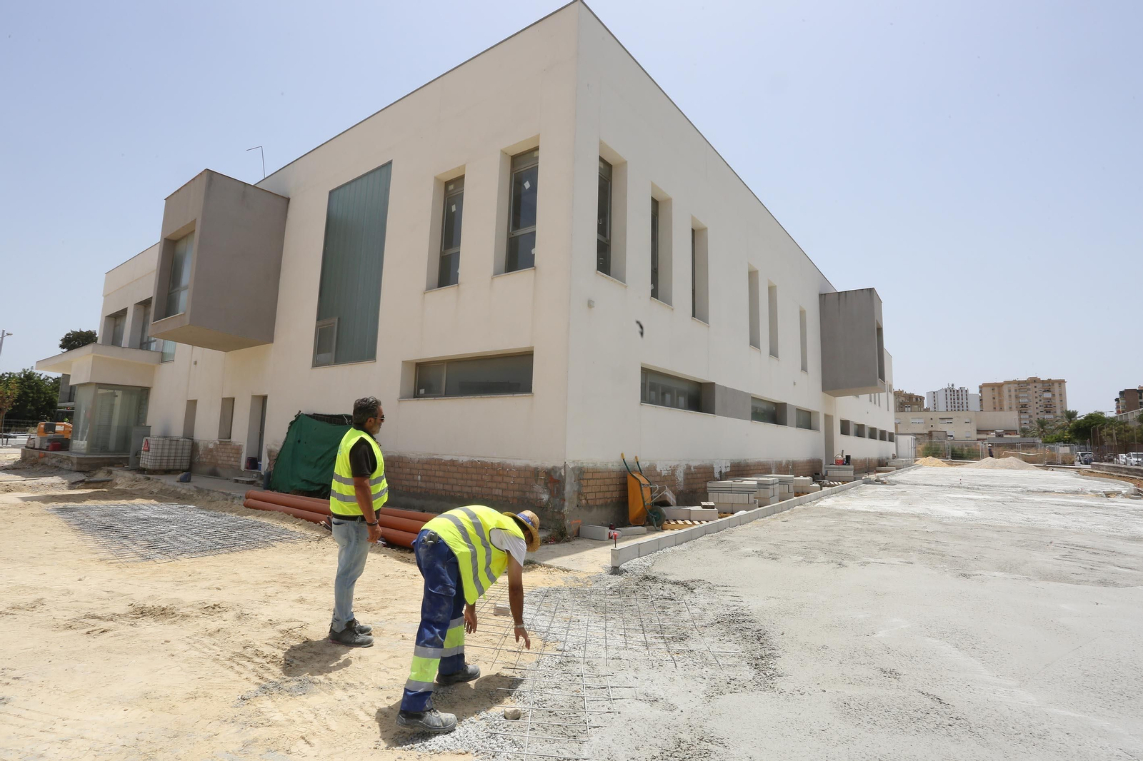 Dos operarios trabajando en la  urbanización exterior de la Jefatura de la nueva Policía Local