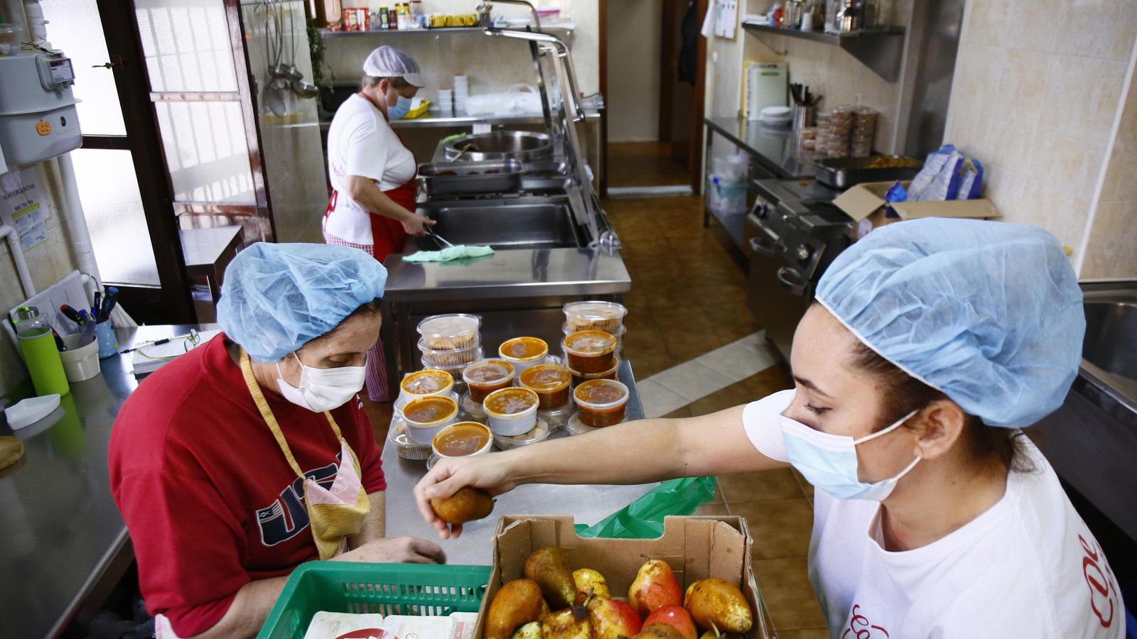 María Luisa y sus ayudantes trabajan en la cocina.