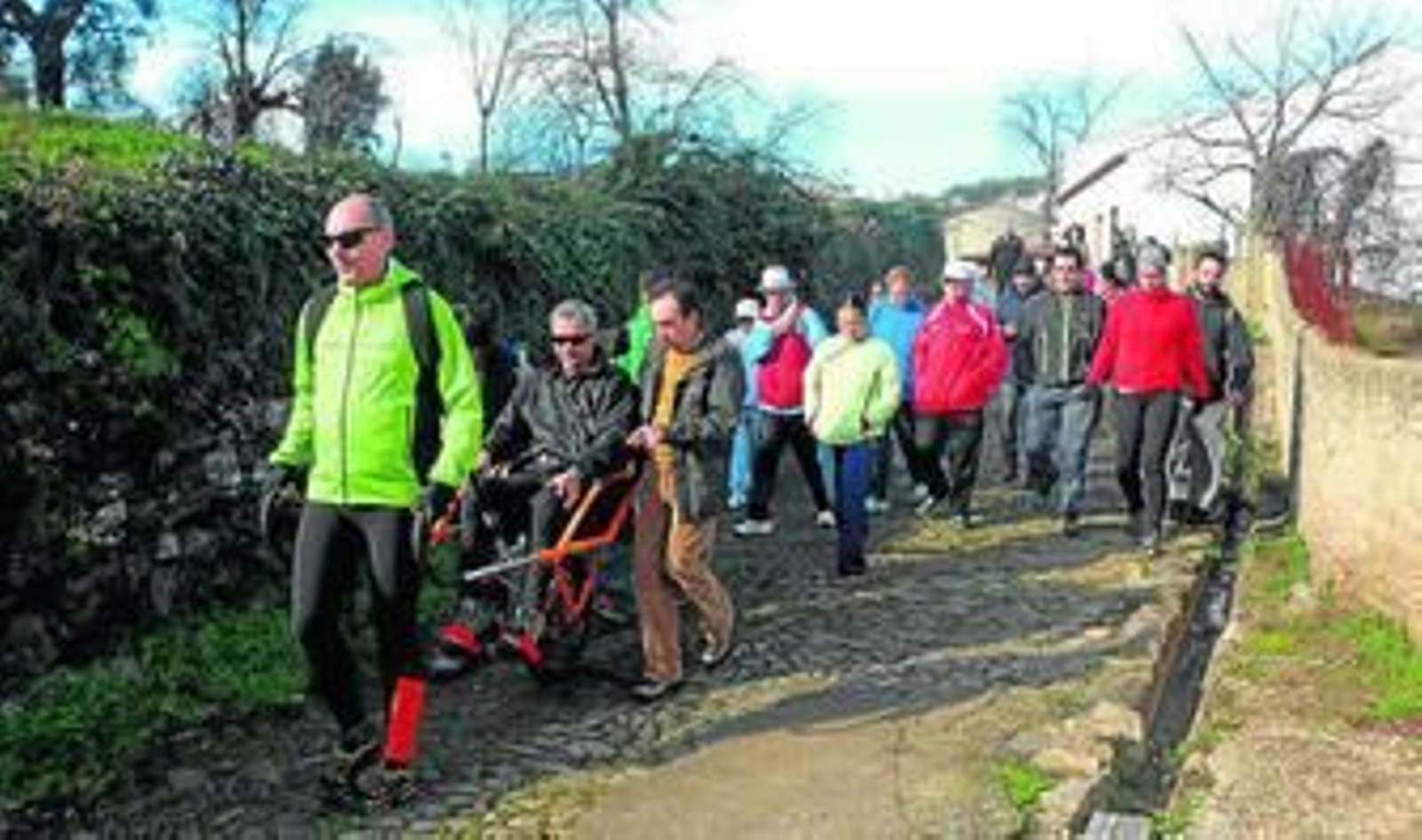 Voluntarios portan la silla en un tramo del sendero realizado.
