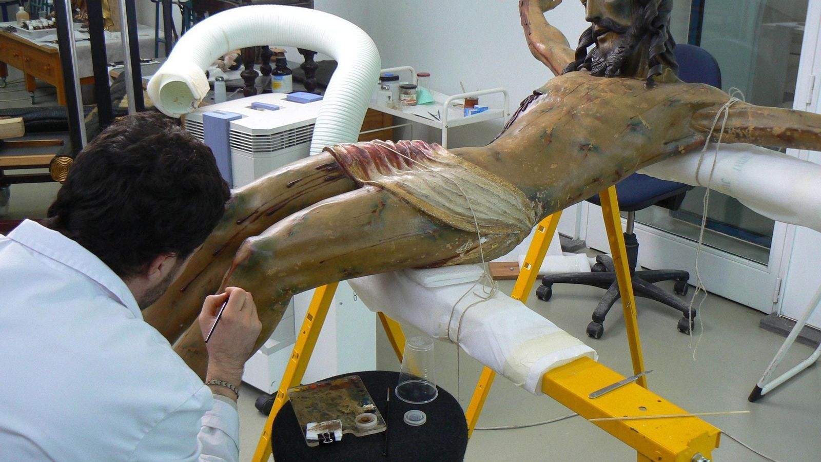 Un técnico trabajando sobre un Crucificado.