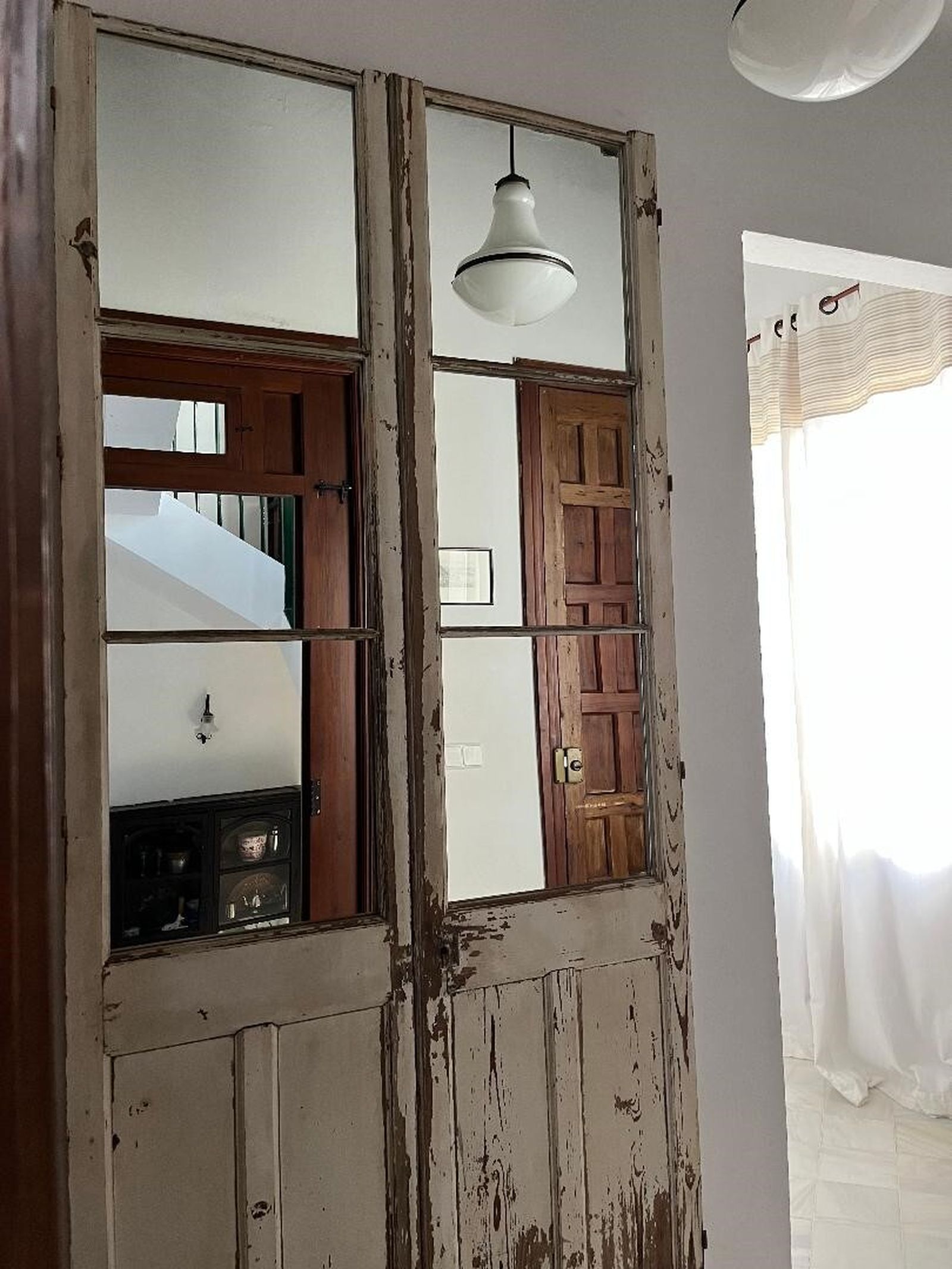 Un espejo realizado con unas viejas puertas.