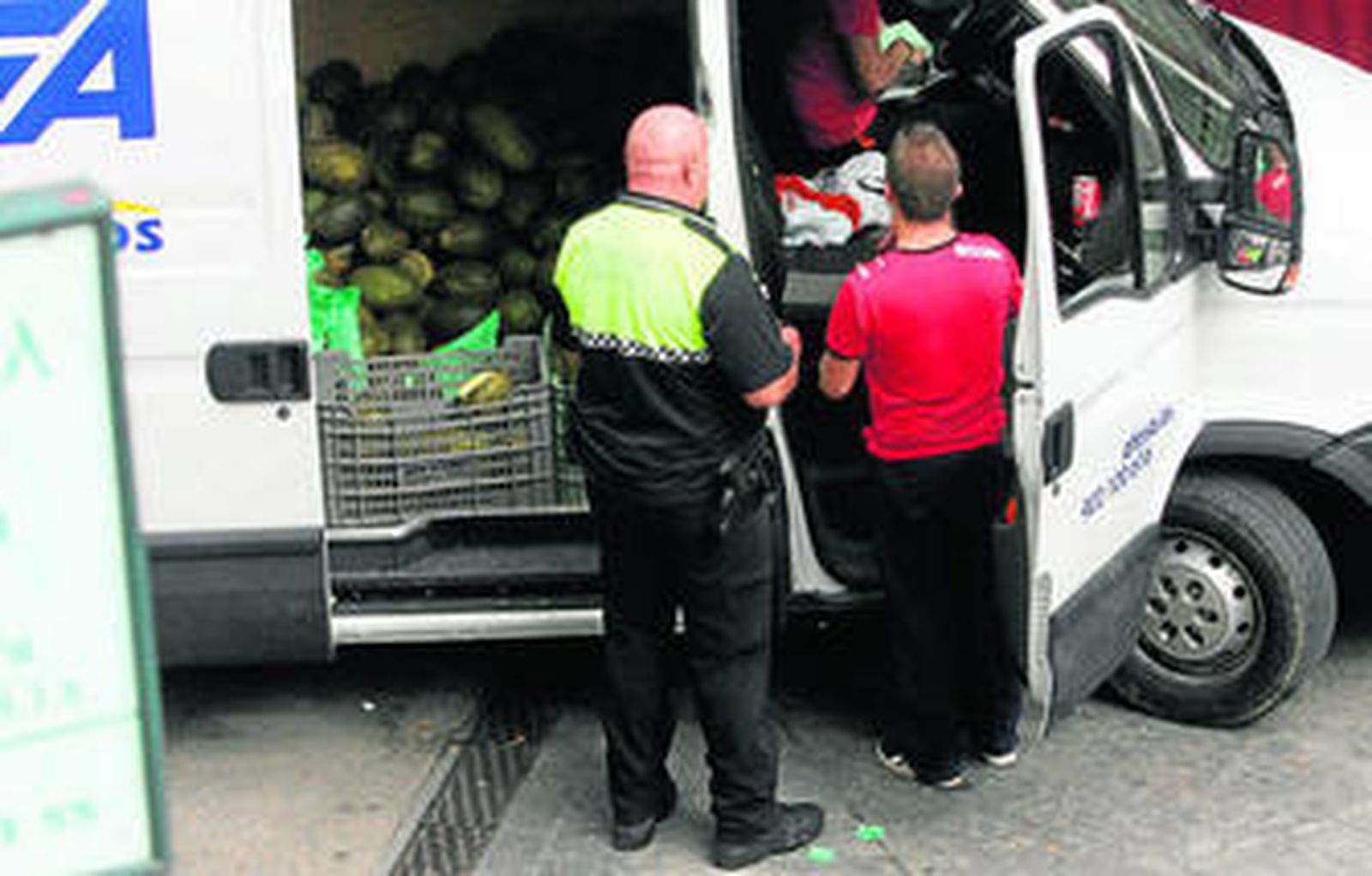 Un Policía Local levanta acta a unos vendedores en una foto tomada ayer.
