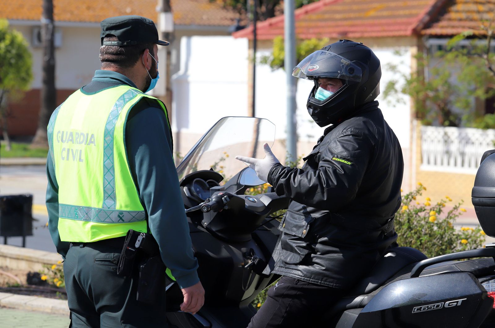 Un agente de la Guardia Civil dialoga con un motorista, en un control en el estado de alarma.