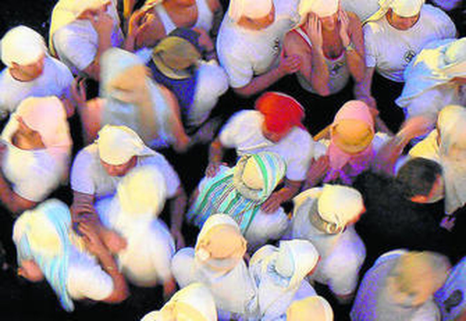 En grupo de costaleros, arremolinados, a la espera del relevo.