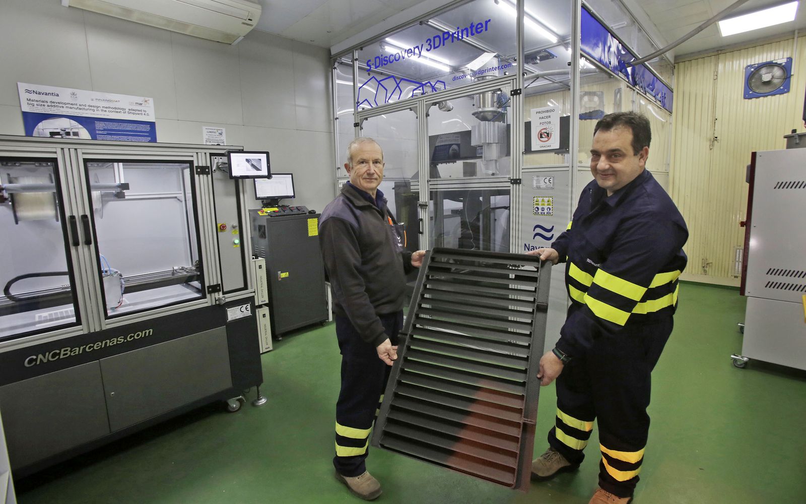 El jefe de proyecto de fabricación aditiva de Navantia, Víctor Casal (derecha), sosteniendo la rejilla.