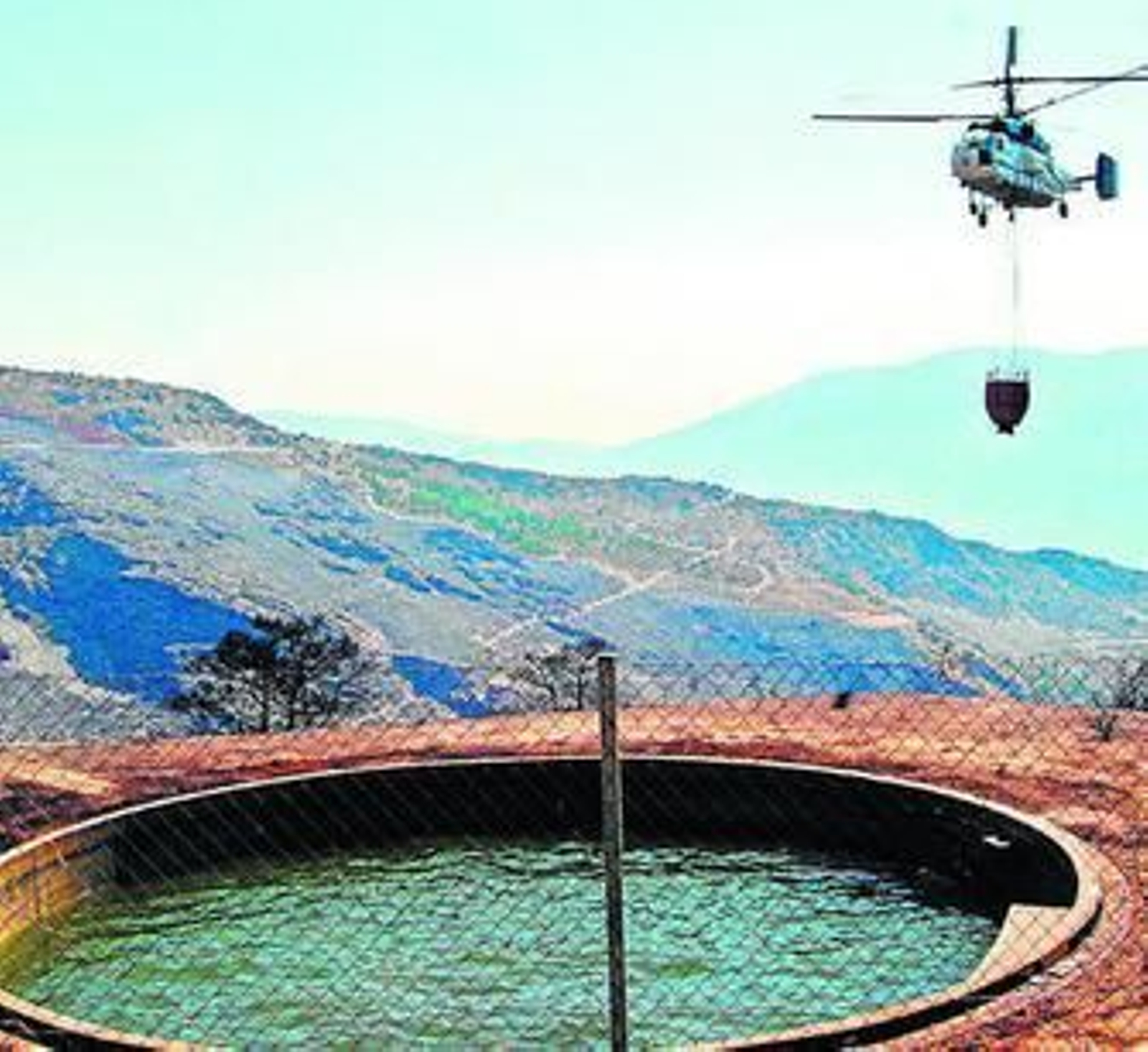 Un helicóptero se acerca a una de las balsas del Infoca en Granada.