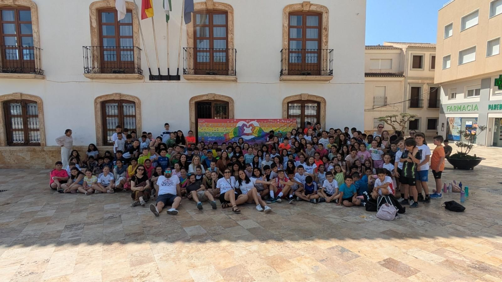 El alumnado ha decorado una gran pancarta con la bandera arcoíris en la Plaza Mayor.