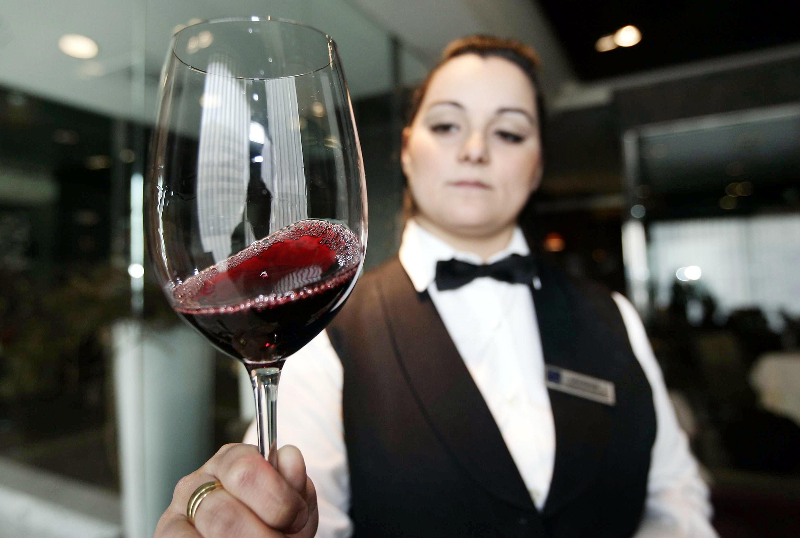 Una sumiller comprueba la capa de un vino tinto.