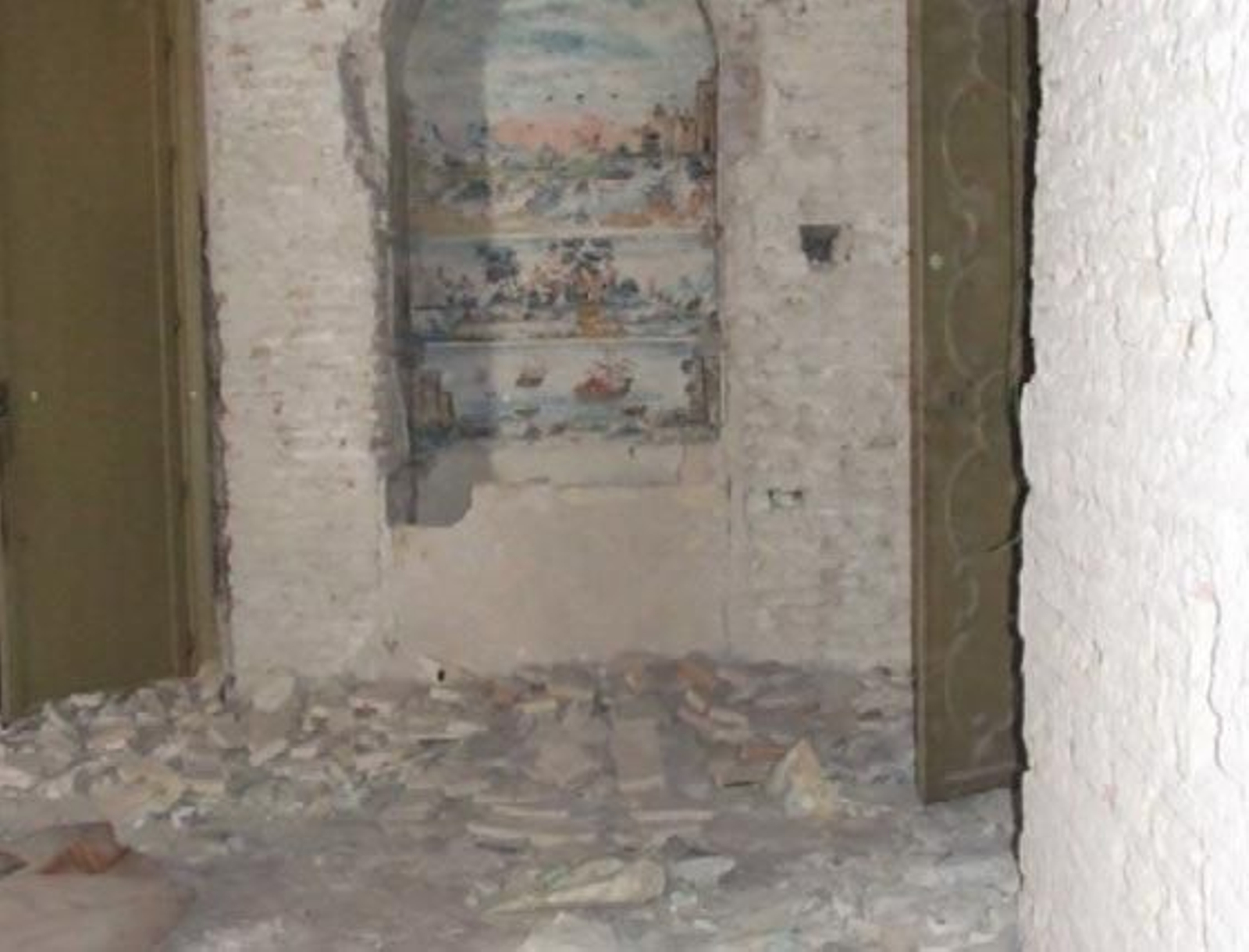 Decoración en la pared, con escombros en el suelo.