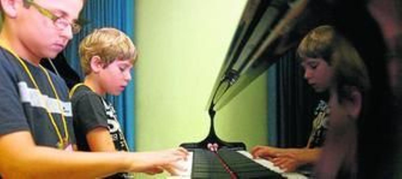 Dos niños tocan el piano en una de las clases impartidas en el Conservatorio de Huelva.