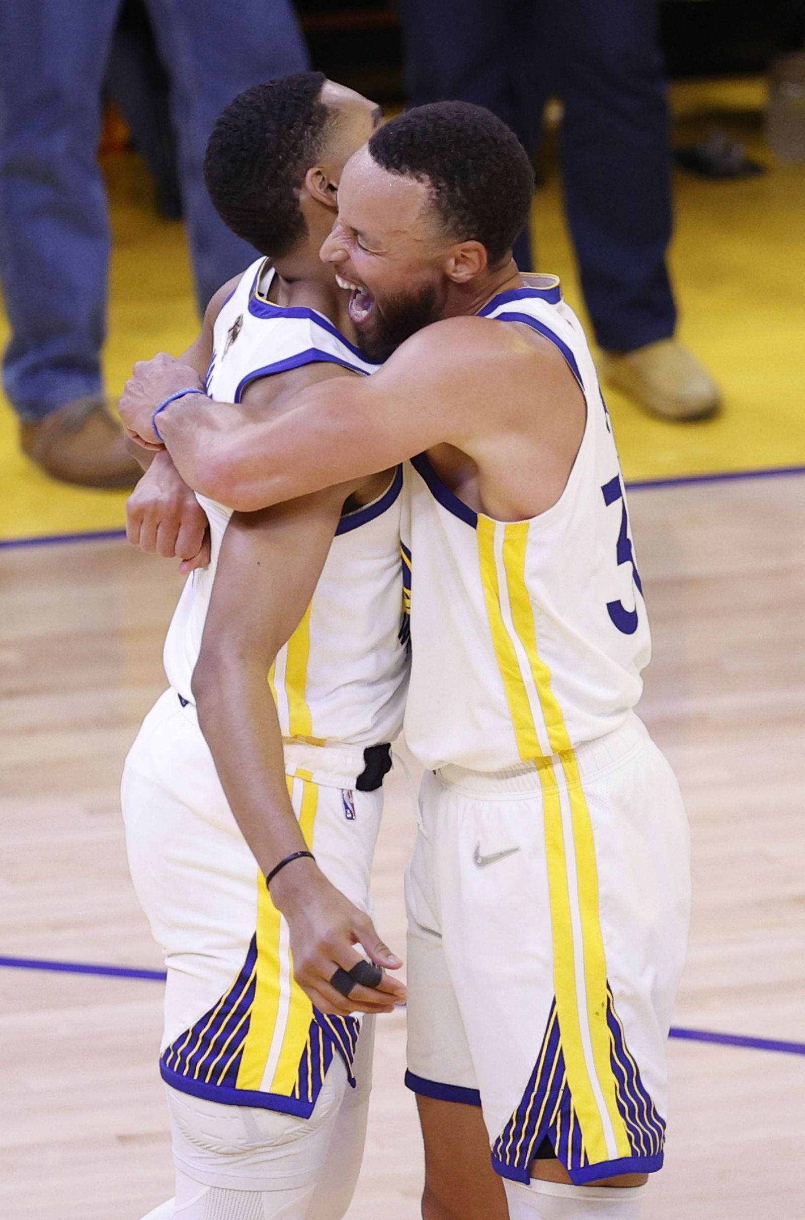 Curry abraza a Jordan Poole tras anotar éste un triple desde el medio del campo.