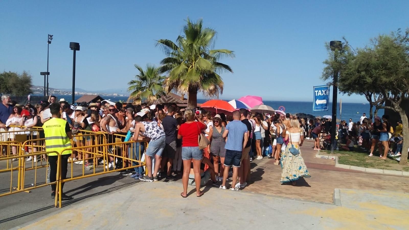 Los seguidores guardan turno pacientemente al sol en los aledaños del recinto.