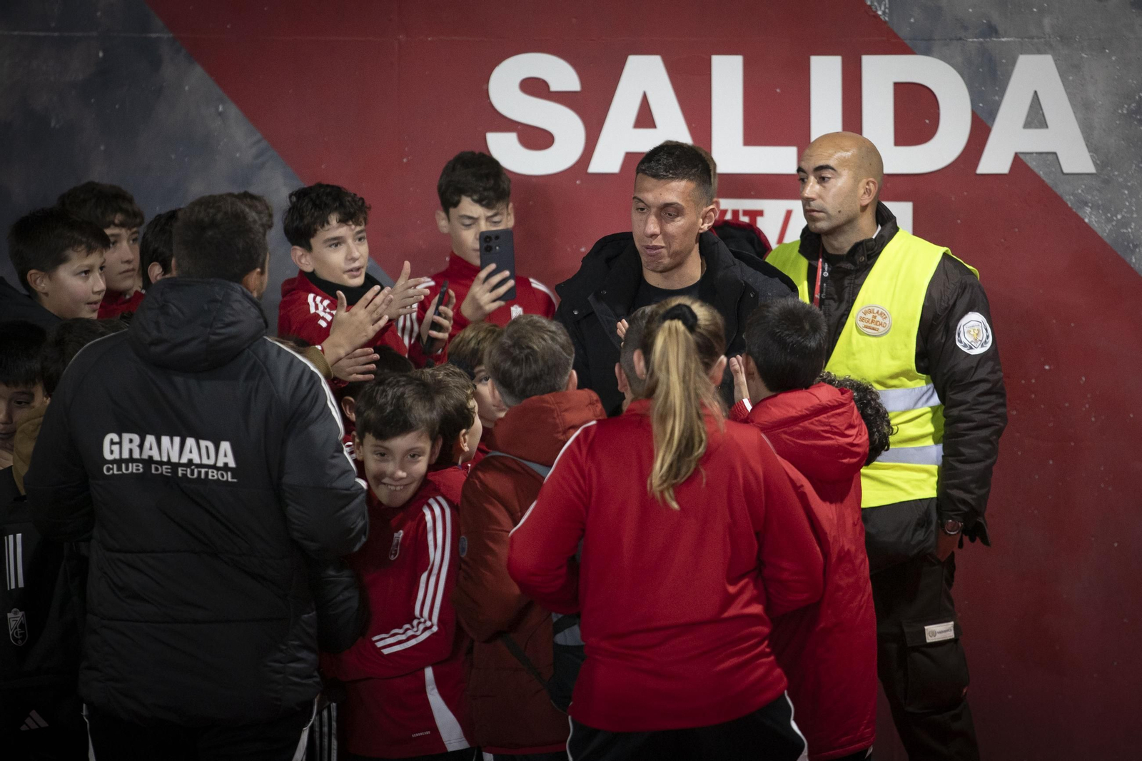 El albanés, rodeado de aficionados en su última vez en Los Cármenes al lado de un cartel premonitorio