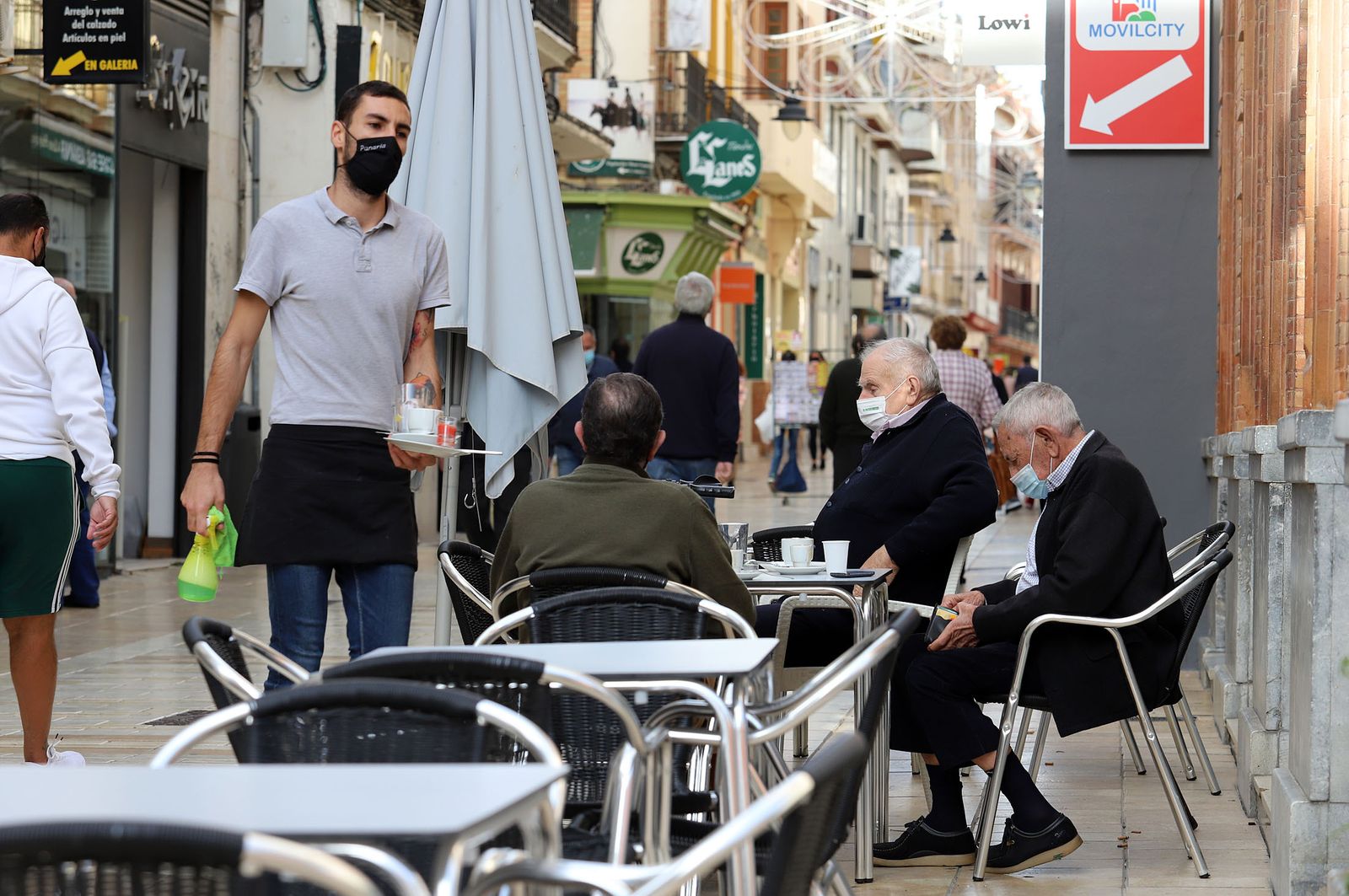 Un camarero atiende a una mesa en un bar.