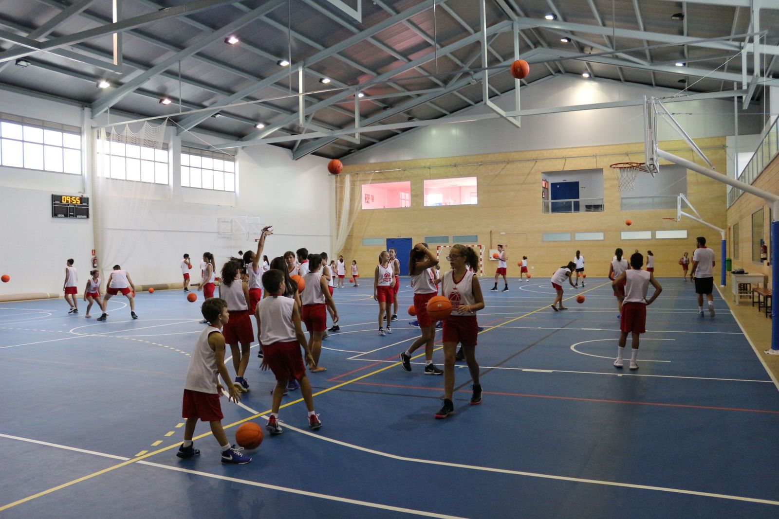 Más de medio centenar de jóvenes practican el baloncesto en el polideportivo.