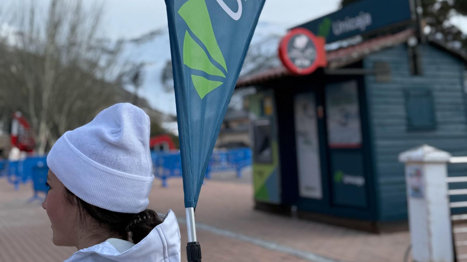 Una joven carga una bandera de Unicaja en Sierra Nevada