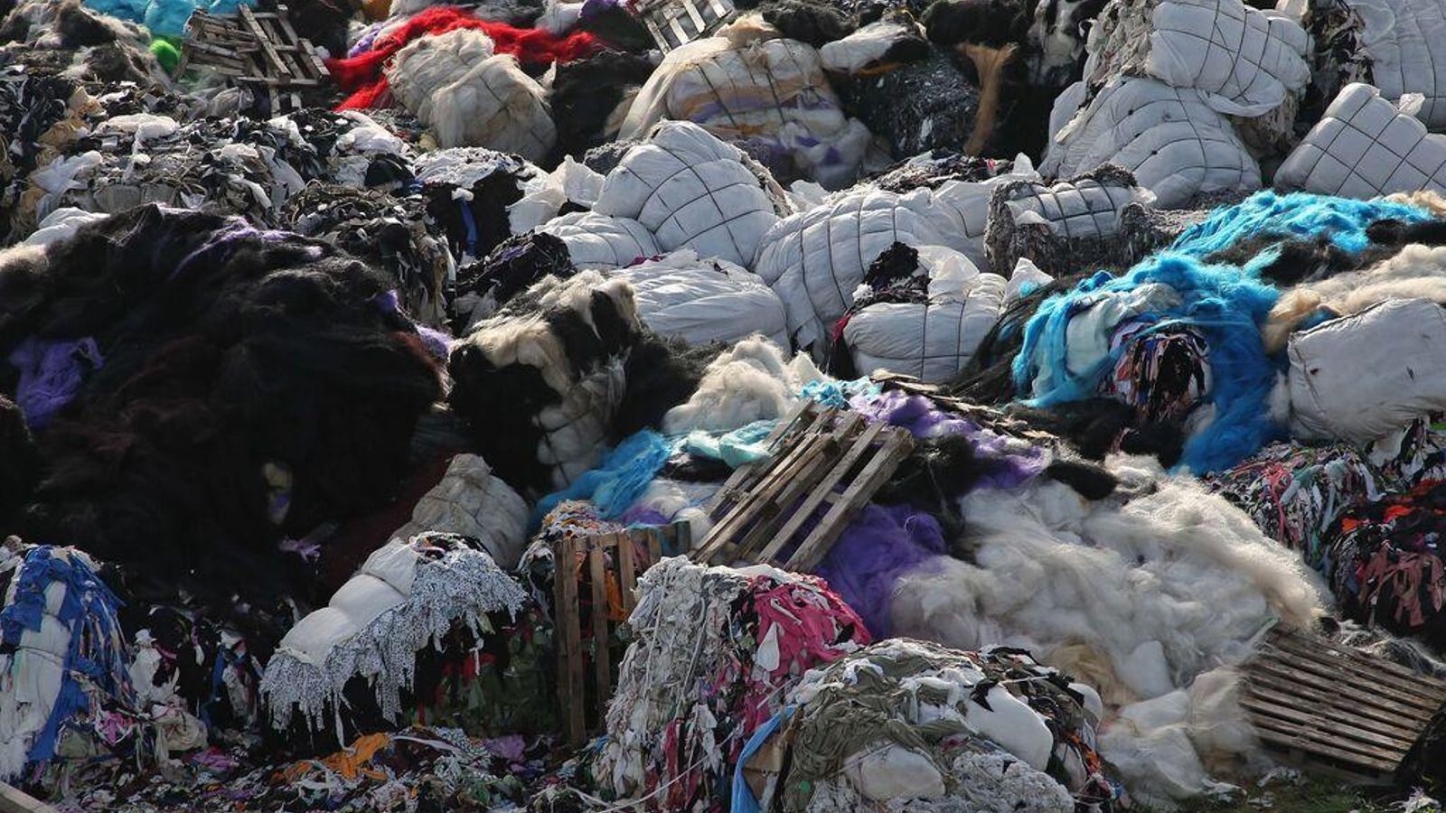 Fardos con sobrantes de tela en un solar del polígono Cortijo Real.