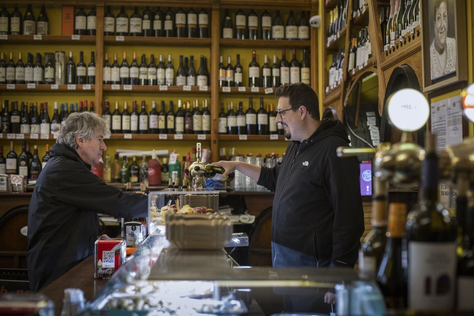 Un camarero sirve una consumición a un cliente en una bodega de Zaragoza.