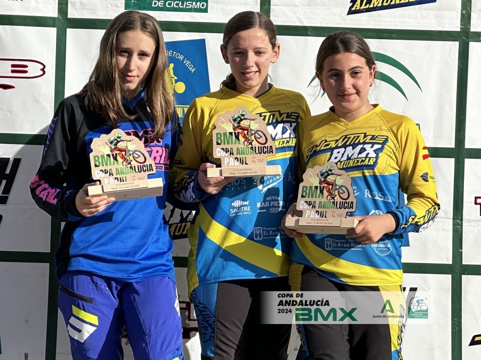 Tres jóvenes ciclistas en el podio.