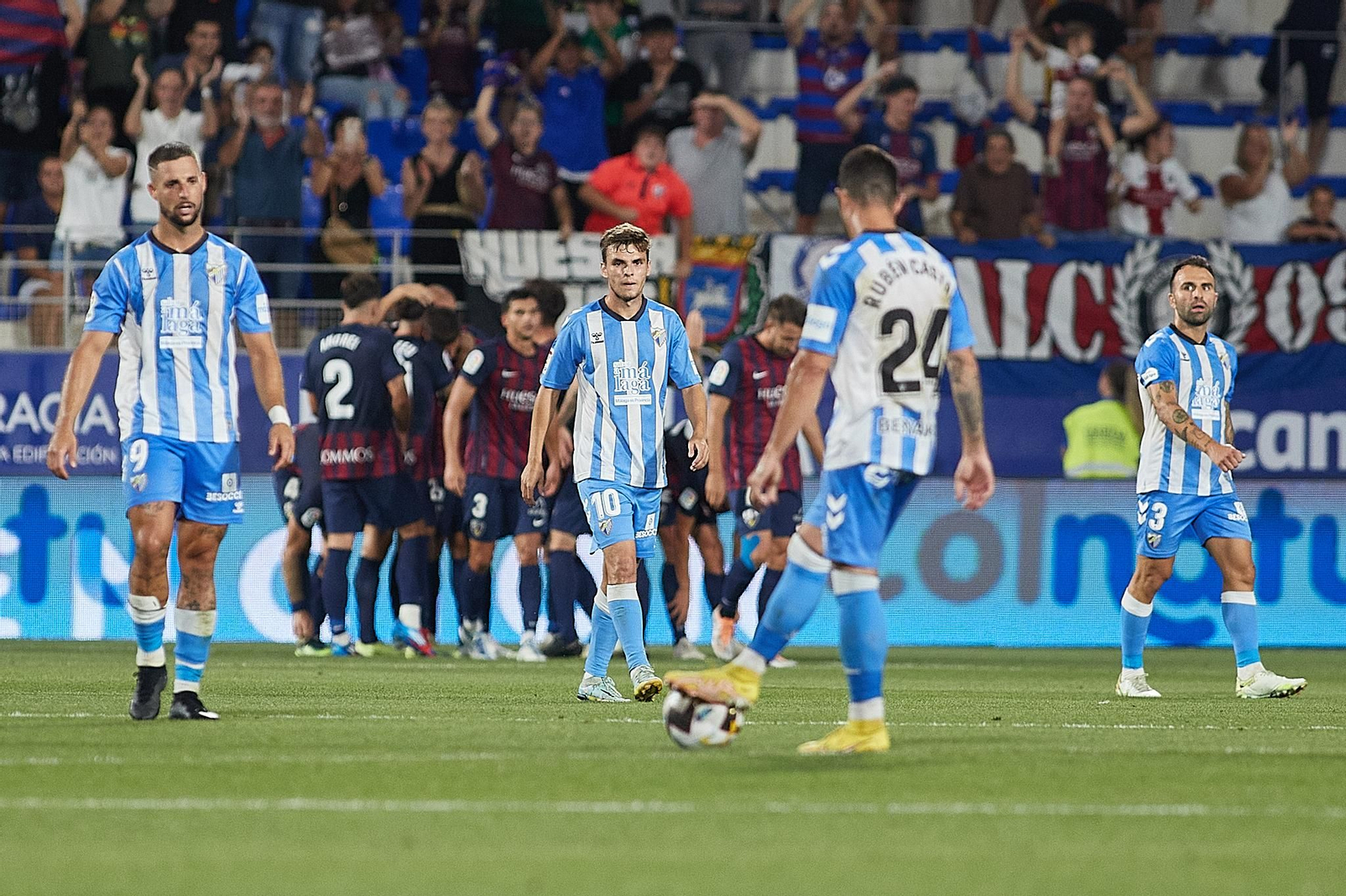 Los jugadores del Málaga, tras el gol del Huesca.