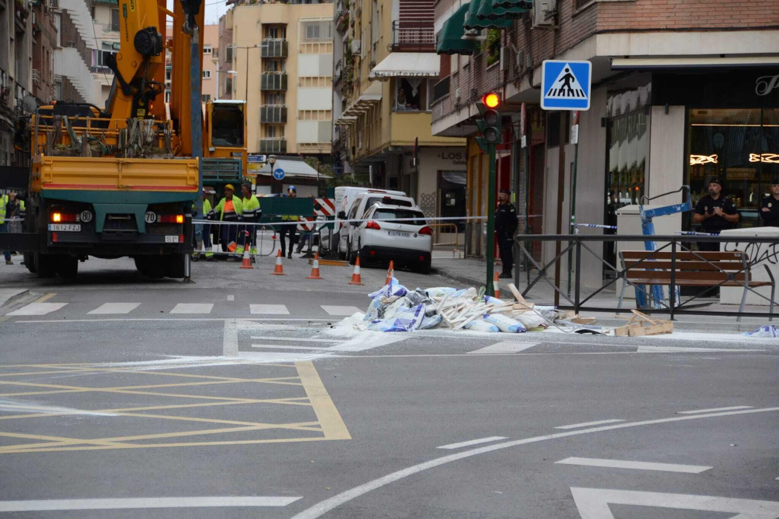 Una mujer resulta ilesa tras caer sobre su vehículo la carga de un camión grúa, en imágenes