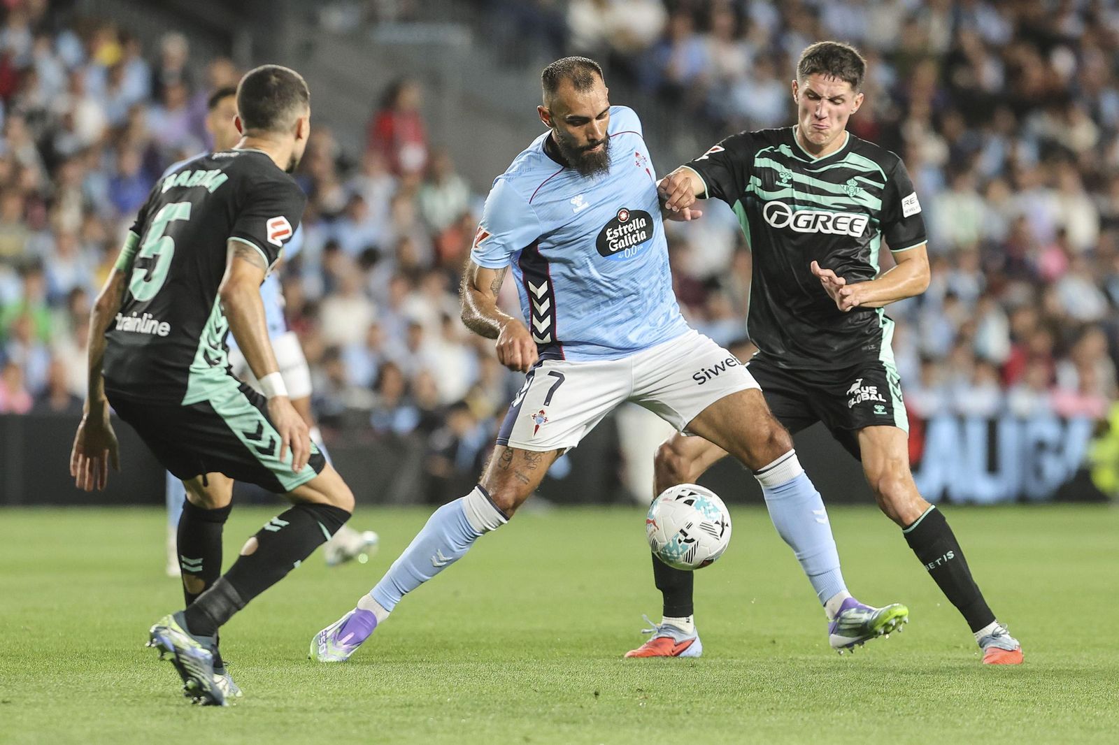 El ex bético Borja Iglesias, entre Bartra y Altimira.