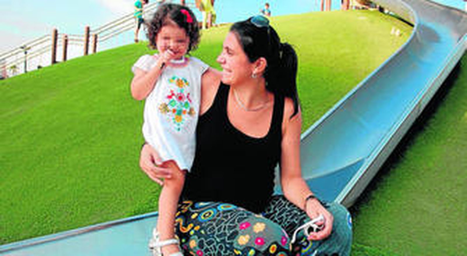 Marina Díaz con su hija en un parque infantil de Málaga.