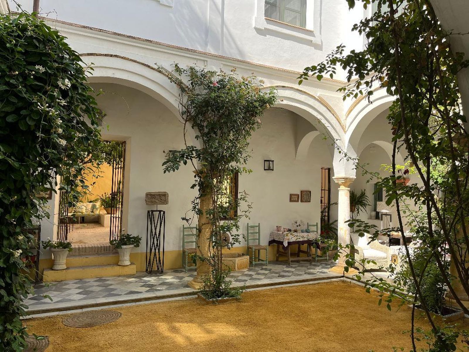 El patio está rodeado de columnas de piedra y arcos donde se mezclan el suelo de damero de mármol de Carrara con el albero.