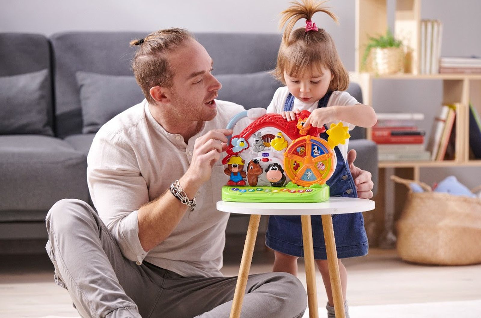 Un padre y una hija juegan con la Granja sonora bilingüe.