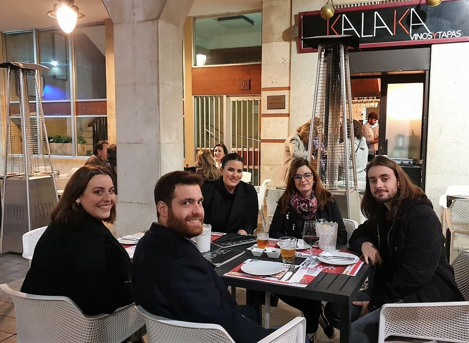 Comensales en una mesa con los manteles de la campaña.