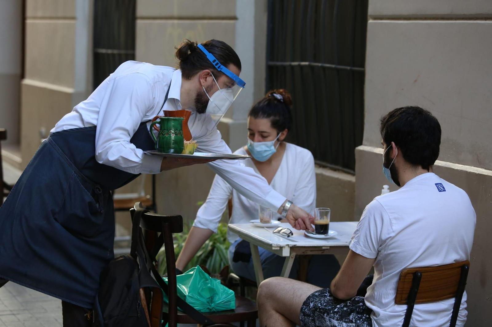 Un camarero sirve el desayuno a dos clientes en un bar del Centro.