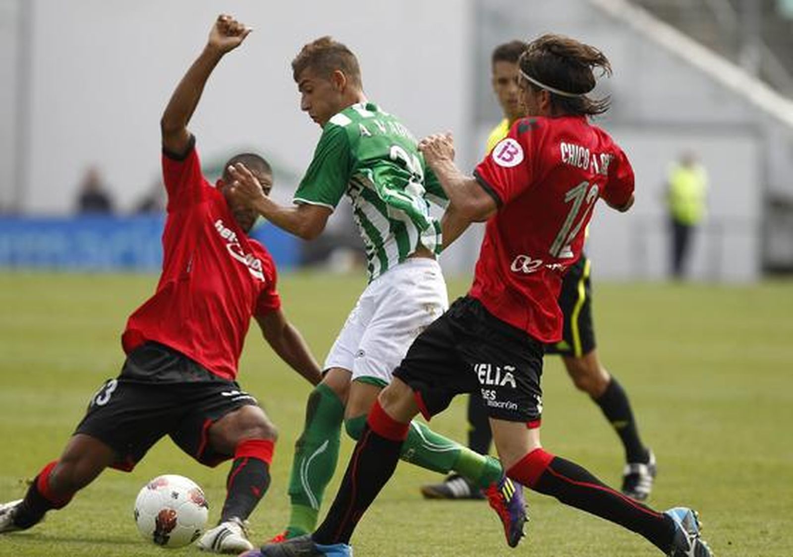 Vadillo trata de sortear a dos jugadores del Mallorca. / Antonio Pizarro