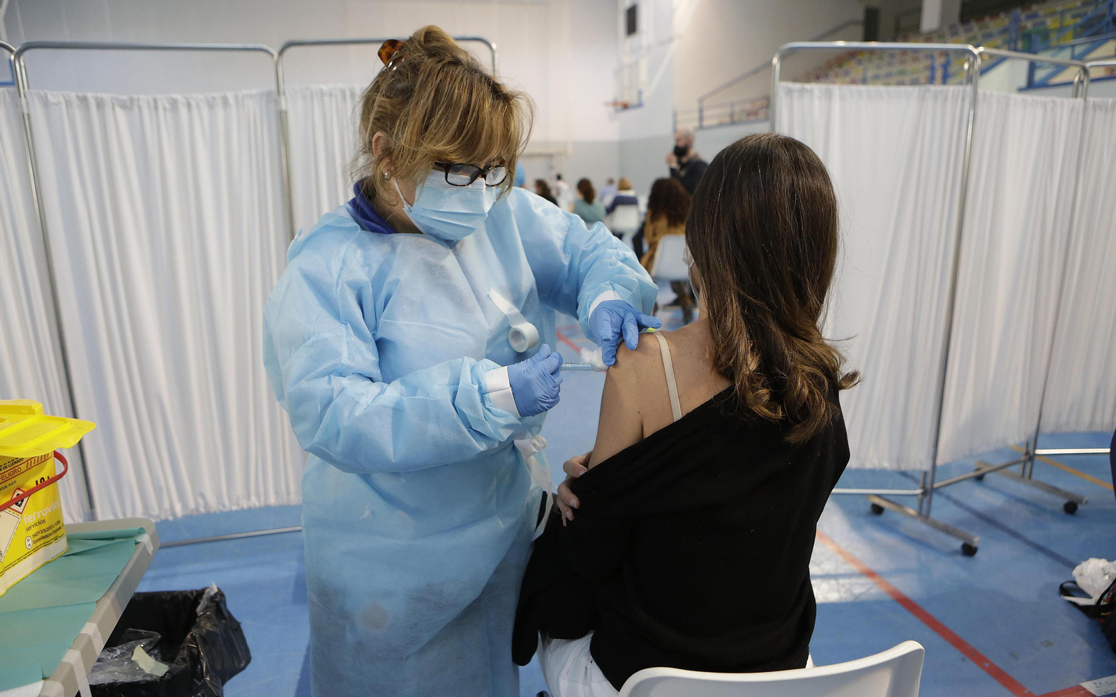 Una enfermera vacuna una dosis de AstraZeneca a una mujer.