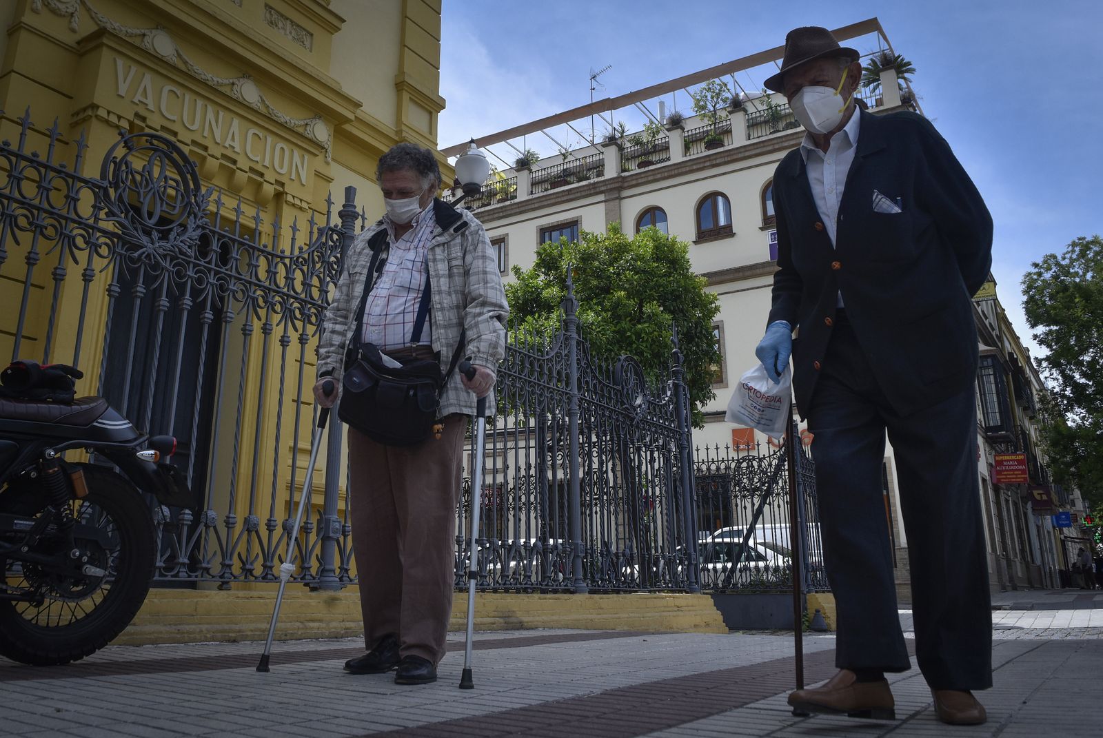 Dos personas mayores, con mascarillas.