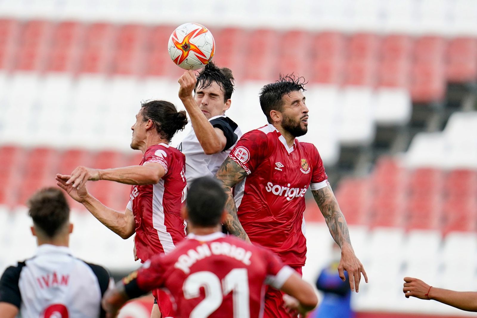 Xavi Sintes salta más que dos rivales del Nàstic en un balón aéreo.