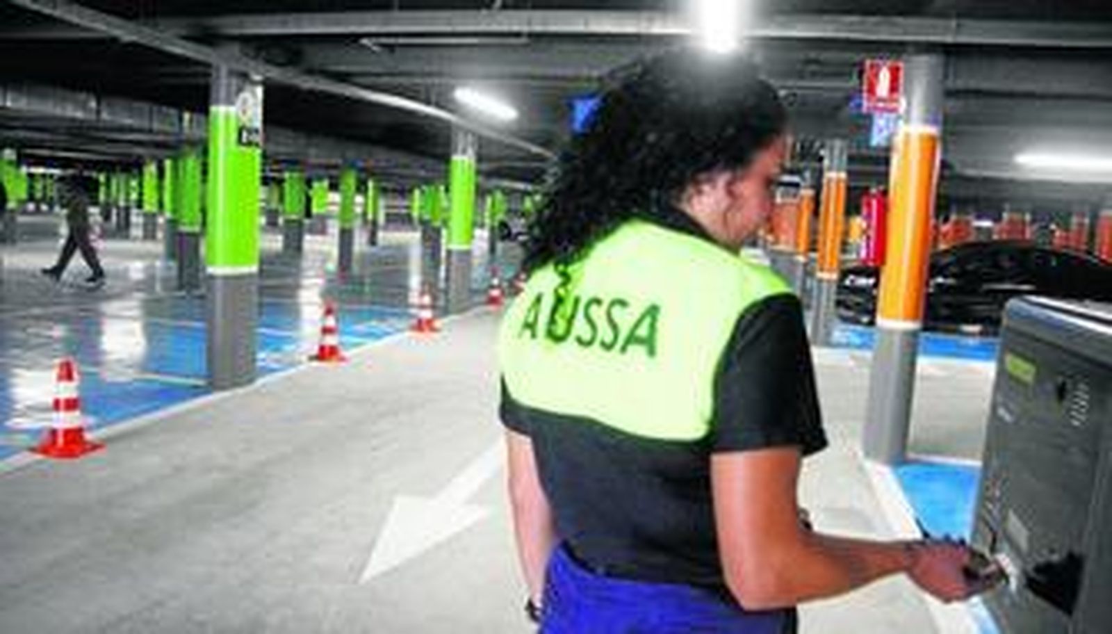 Una trabajadora de Aussa comprueba la máquina expendedora del parking del Arenal.