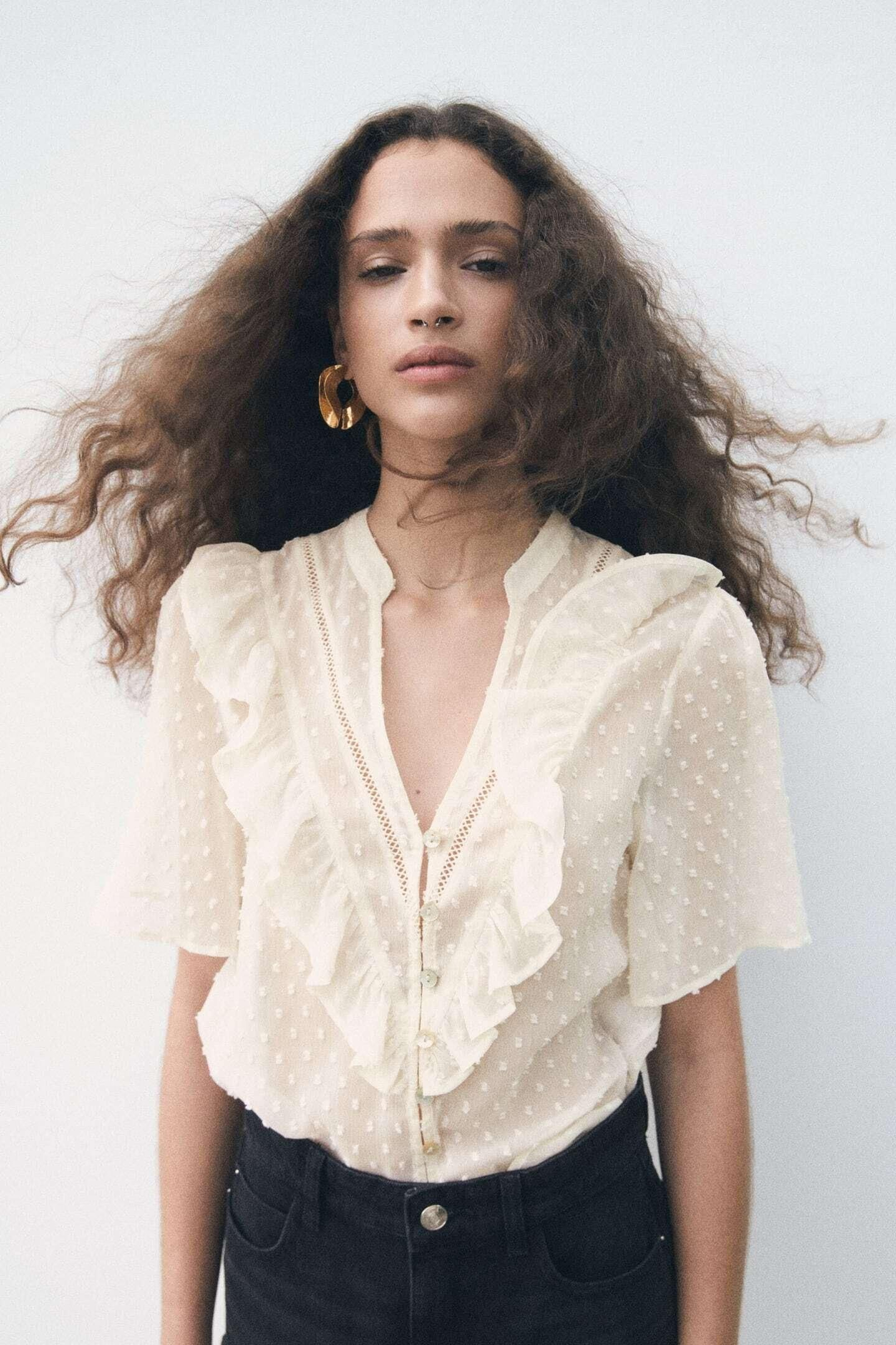 Blusa con volantes y plumeti de Zara.