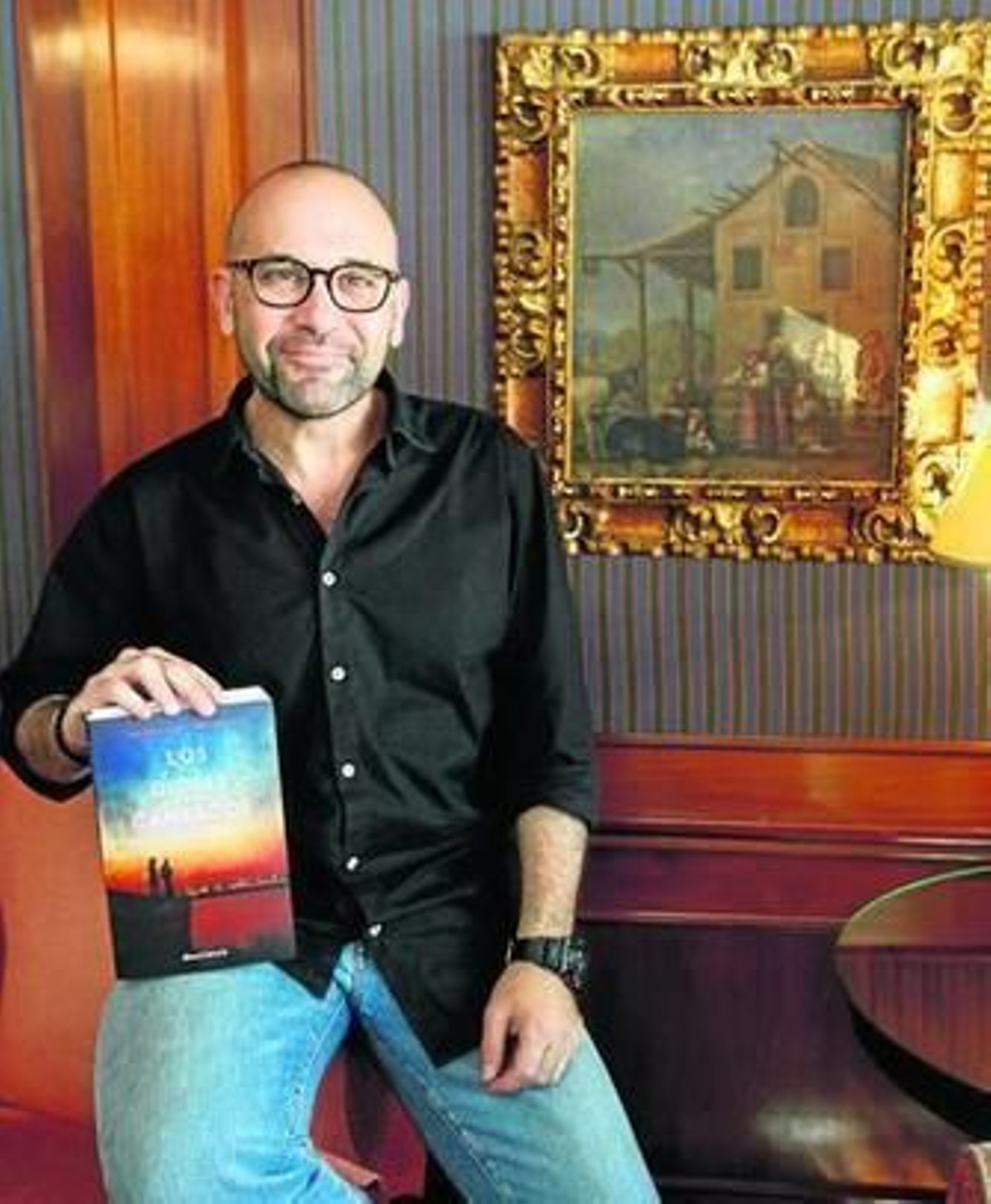 Andrés Pérez Domínguez, en el Hotel Inglaterra con un ejemplar de 'Los dioses cansados'.