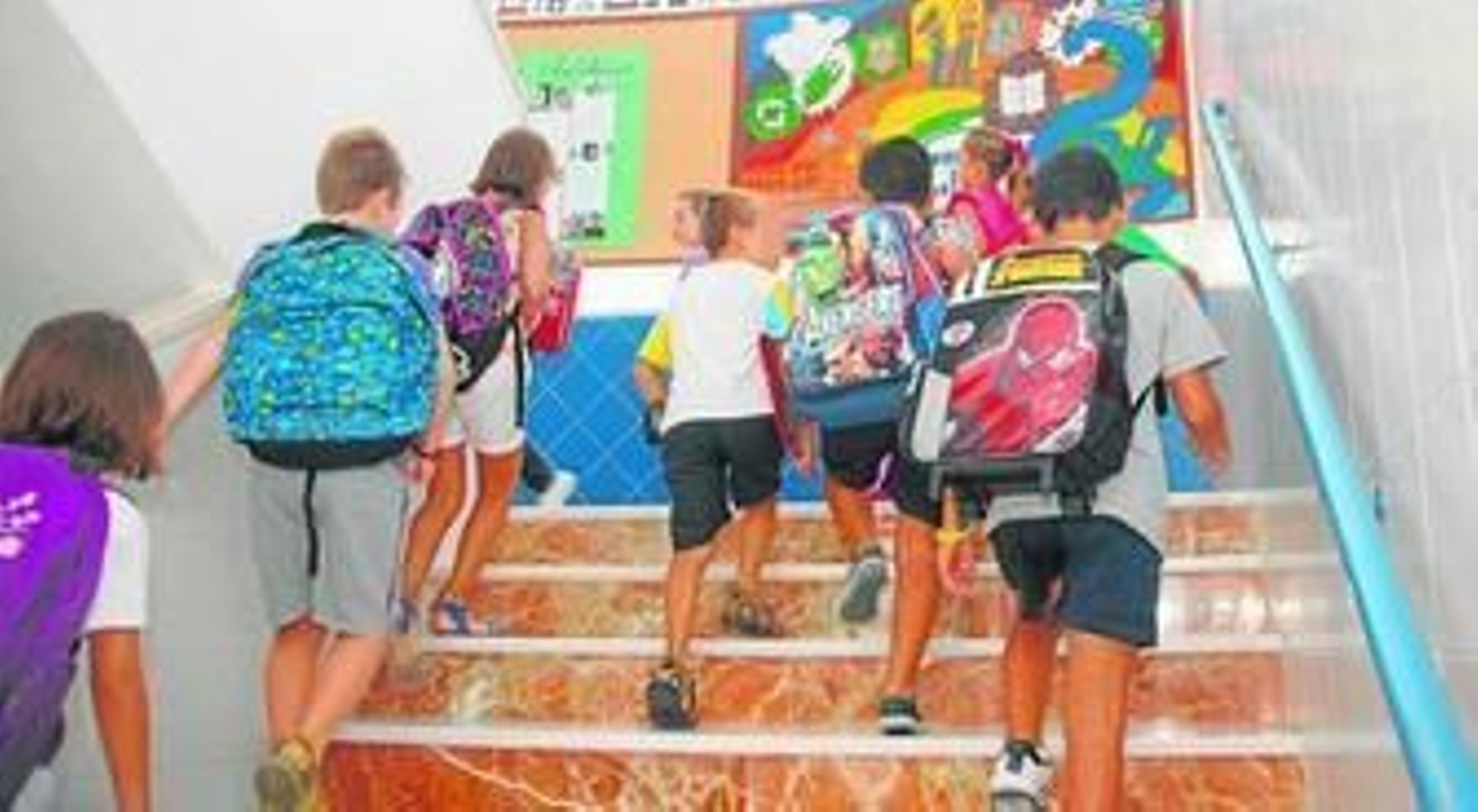 Niños cargados con sus mochilas entrando a clase en una imagen de archivo.
