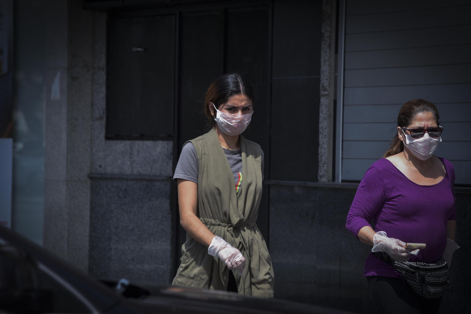 Dos mujeres con mascarilla y guantes.