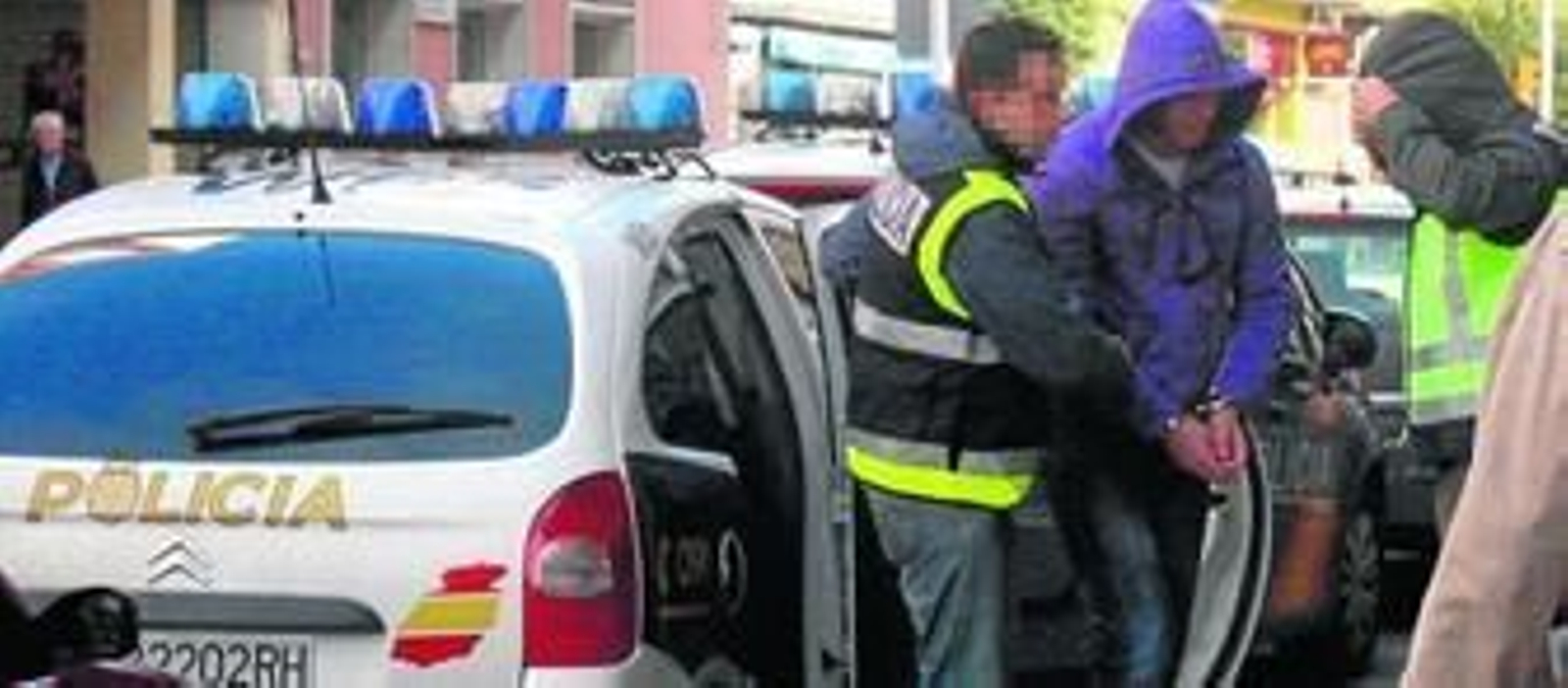 El presunto asesino de Amelia, esposado y tapado con una capucha entre dos agentes, ayer a su llegada al domicilio de Federico Molina custodiado por la Policía Nacional.