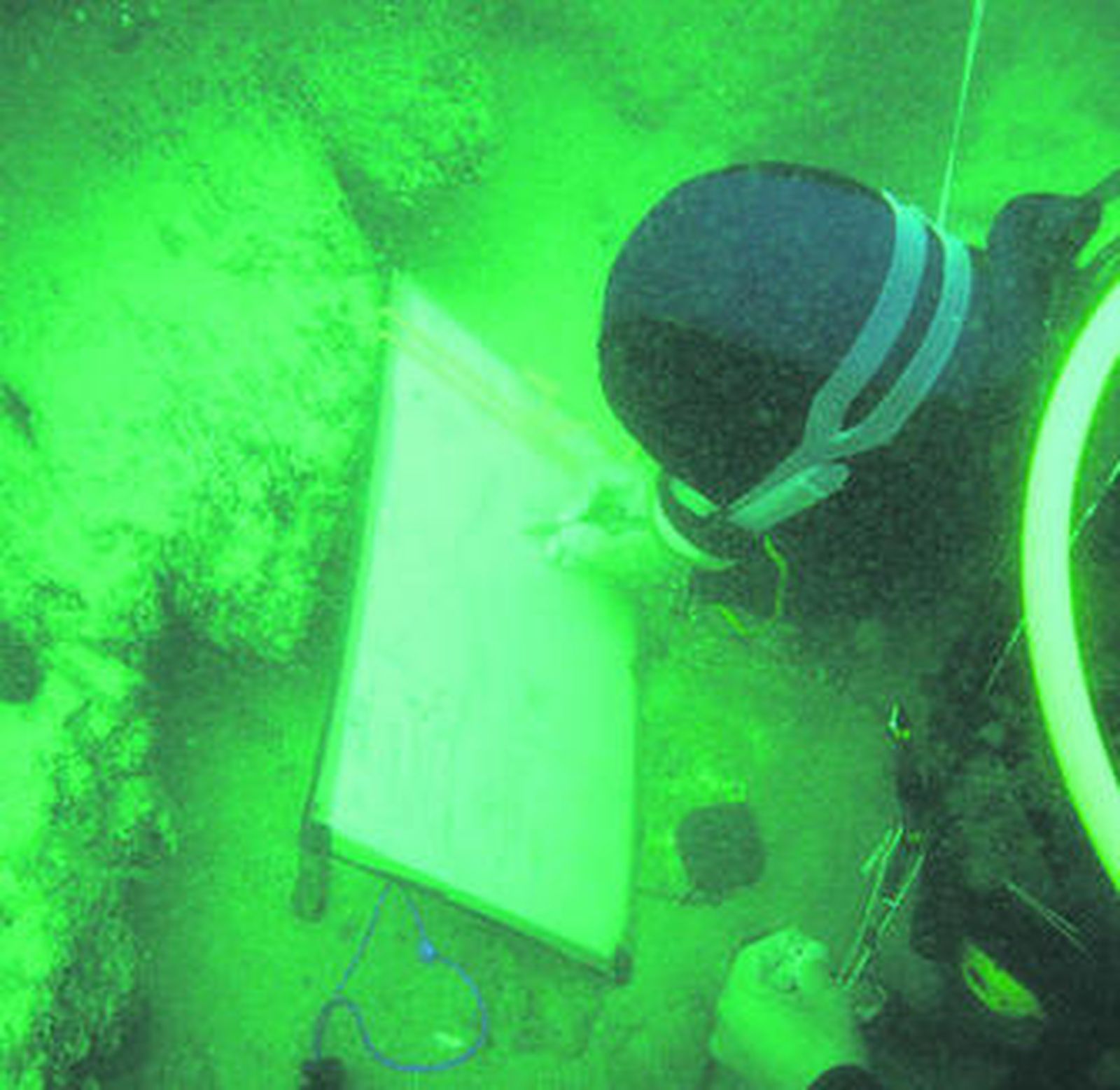Un arqueológoco del CAS dibuja restos en un yacimiento.