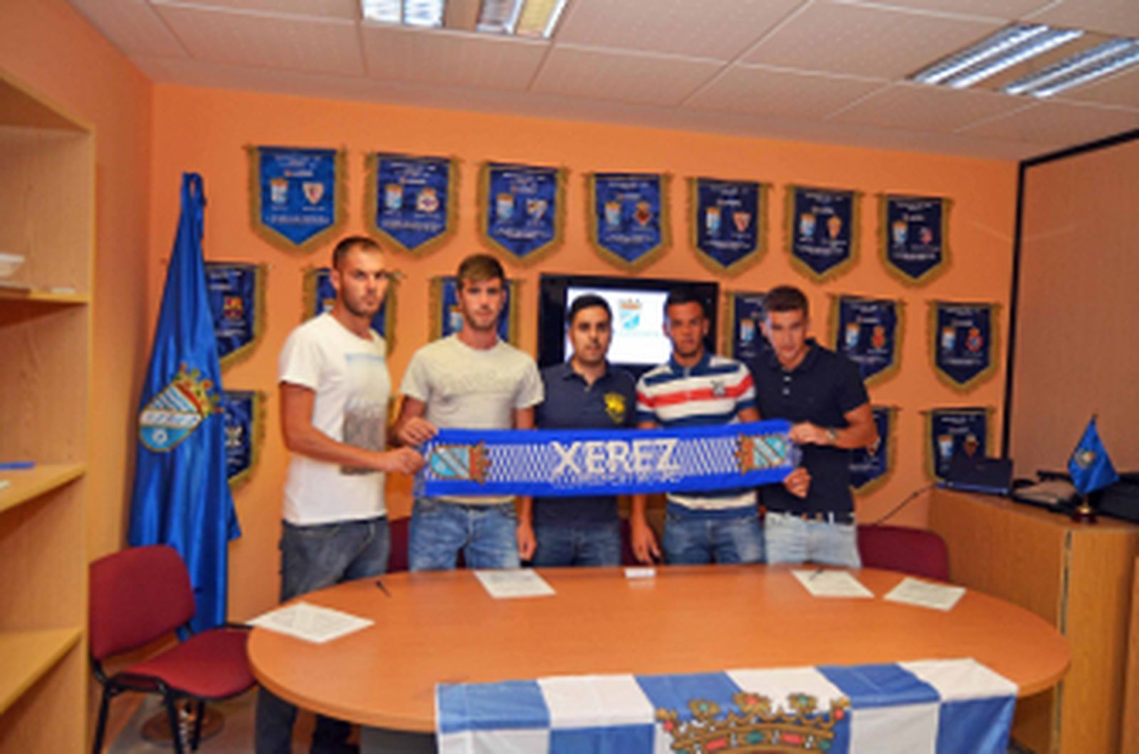 Los cuatro fichajes, a ambos lados del responsable directivo del club, levantan con orgullo la bufanda del que es ya su equipo/Manu García