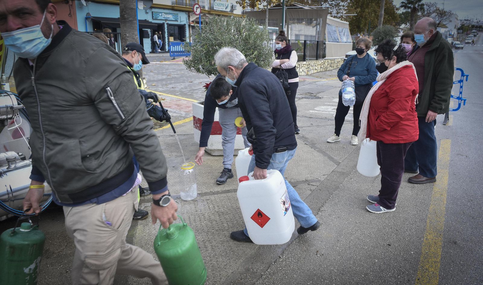 Ciudadanos haciendo cola para llegar garrafas ante un camión cisterna, en Arahal.