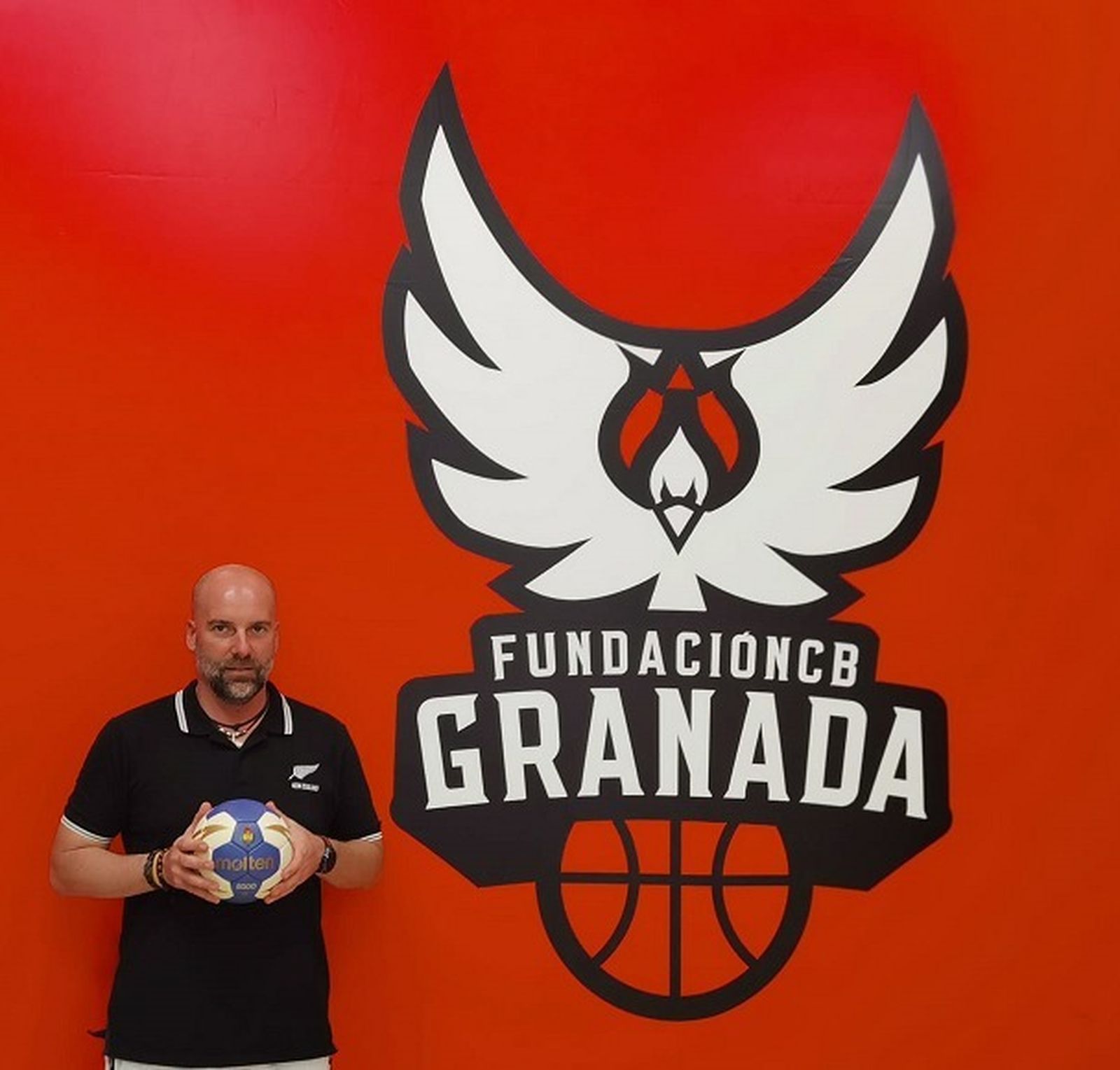 Pablo Perea posa junto al escudo del Fundación Balonmano Granada.
