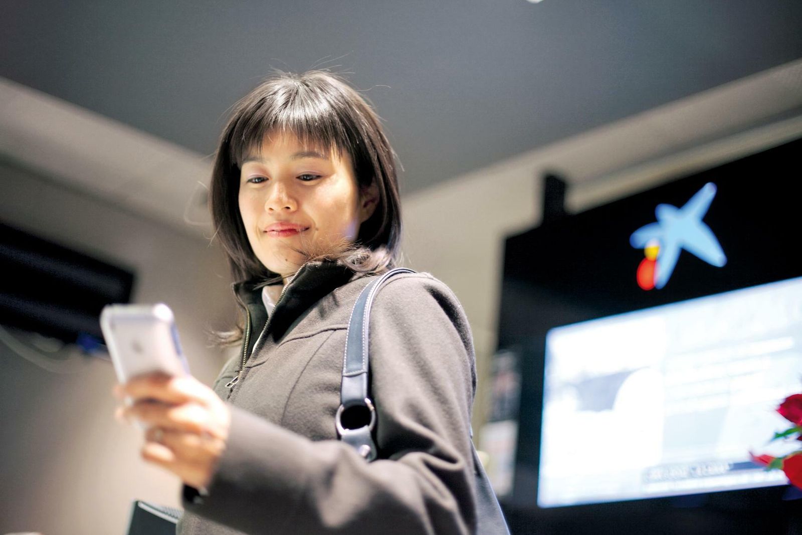 Una usuaria consulta en el móvil la aplicación de Caixabank