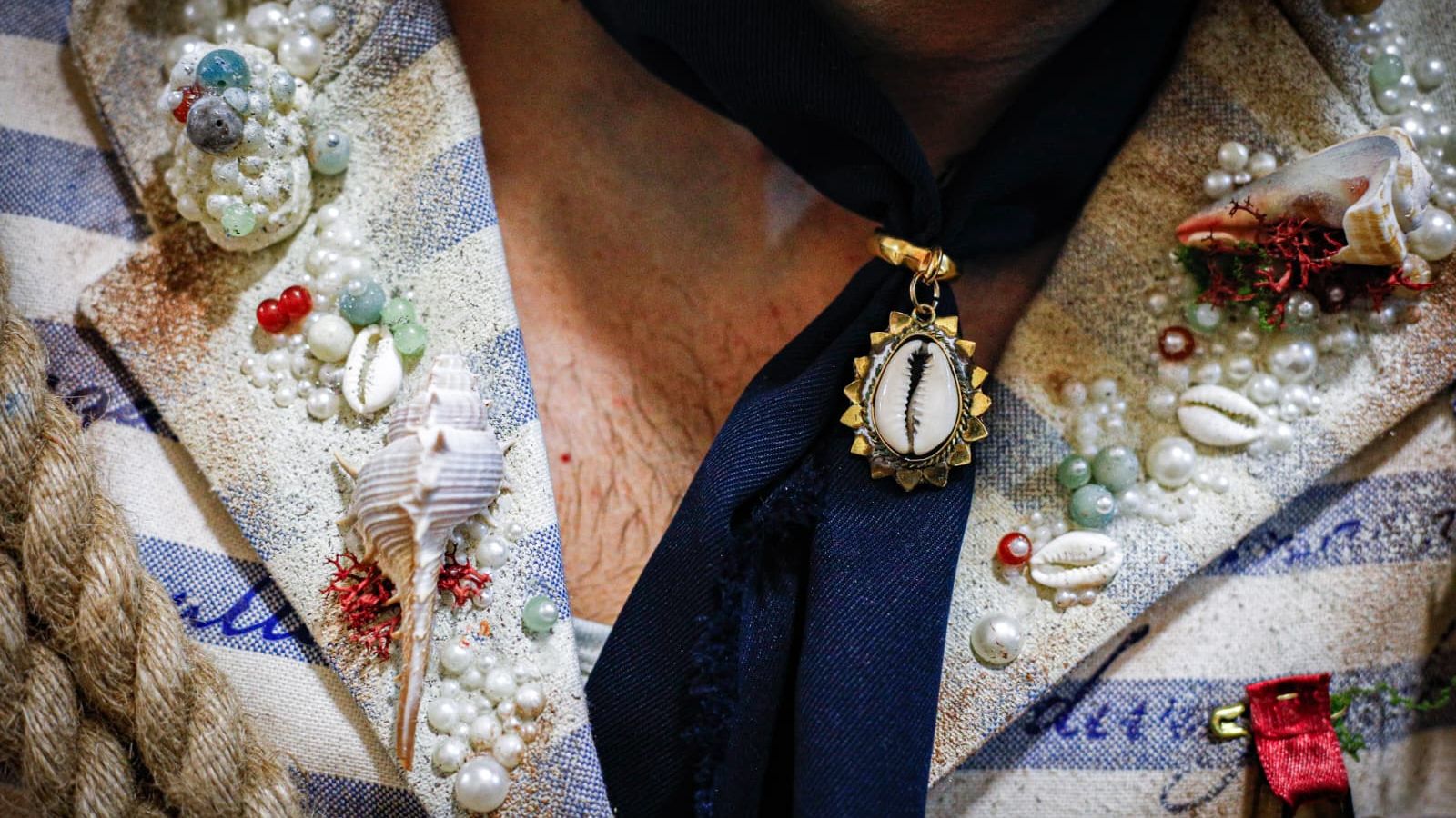 Detalles de la solapa con el pañuelo, pedrería, caracolas y conchas