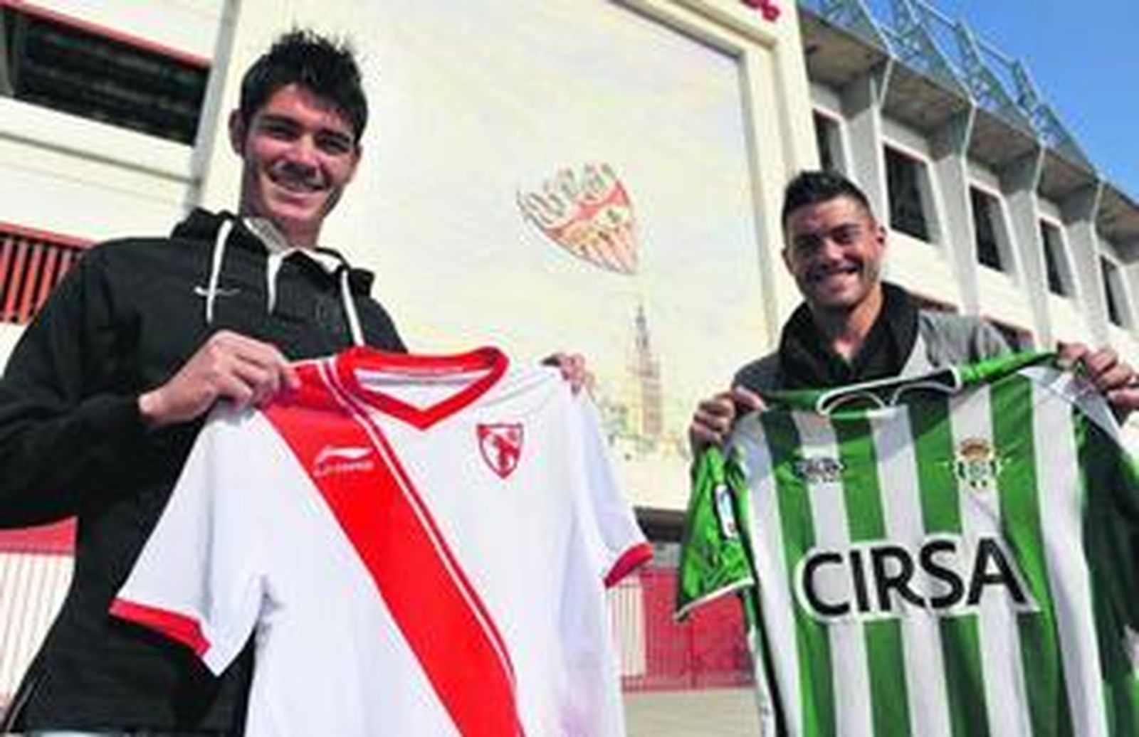 Jozabed y David Agudo posan con las camisetas de Sevilla Atlético y Betis B delante del mosaico del Gol Sur del Ramón Sánchez-Pizjuán.